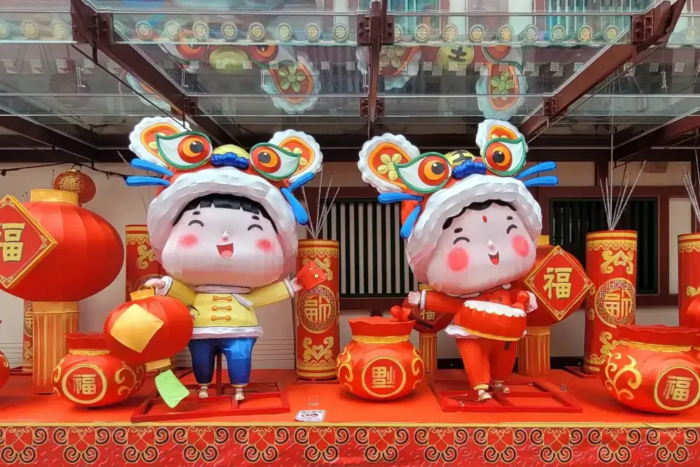 Cute lion dance figurines and red lantern decorations for Chinese New Year in Singapore’s Chinatown.