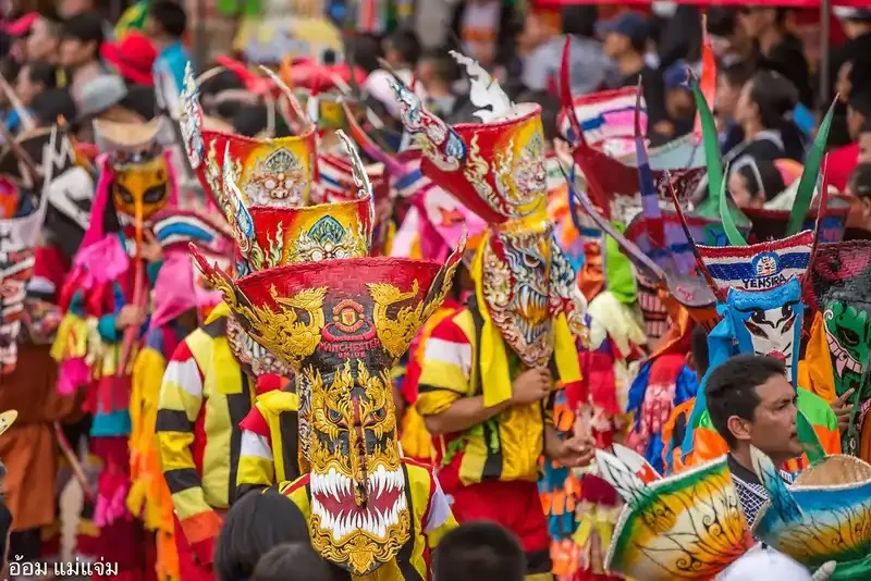 Colorful masked dancers celebrating Phi Ta Khon ghost festival in Loei, Thailand.