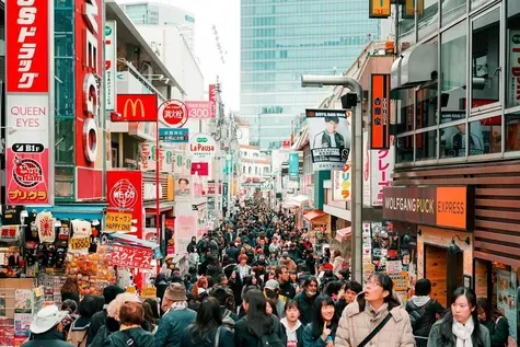 Crowded Takeshita Street in Harajuku, Tokyo, filled with tourists and colorful signage during peak hours.