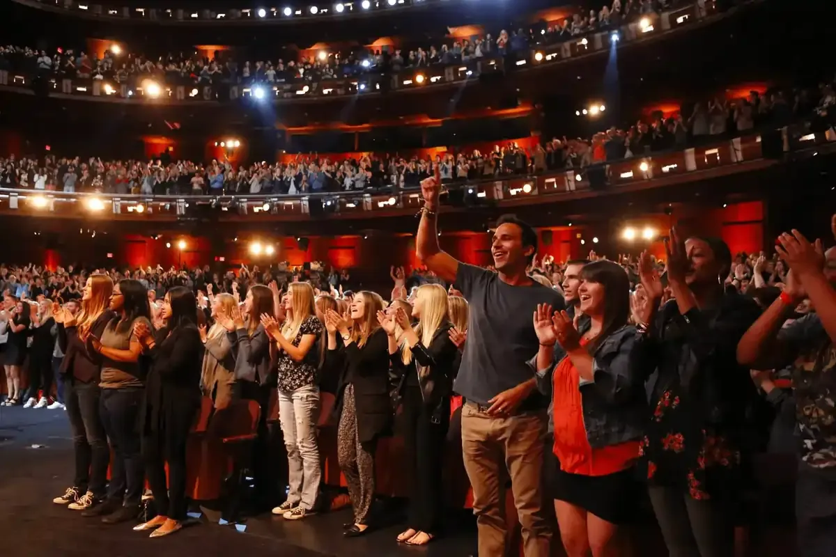 Audience giving a standing ovation at a live studio taping.