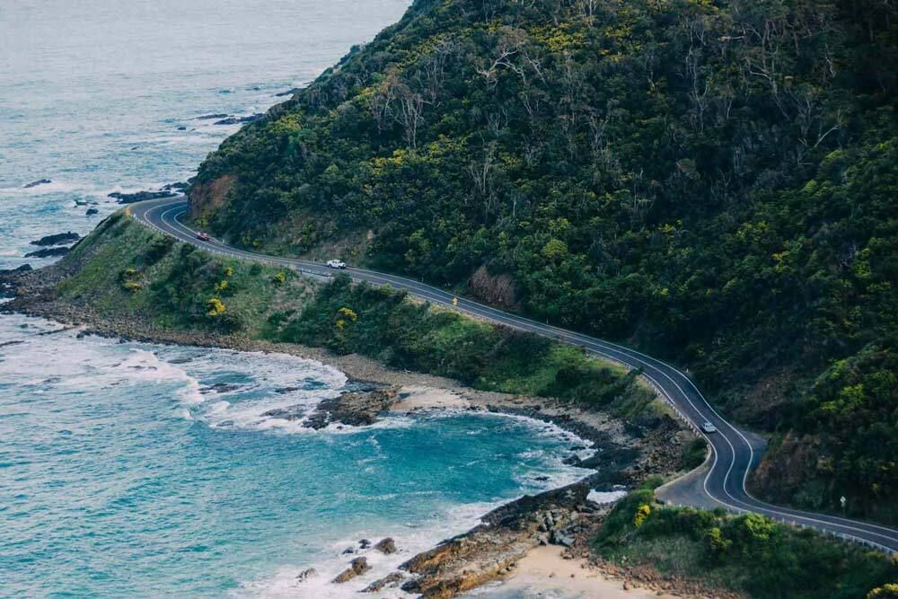 Aerial view of a winding road along the ocean coast in Australia