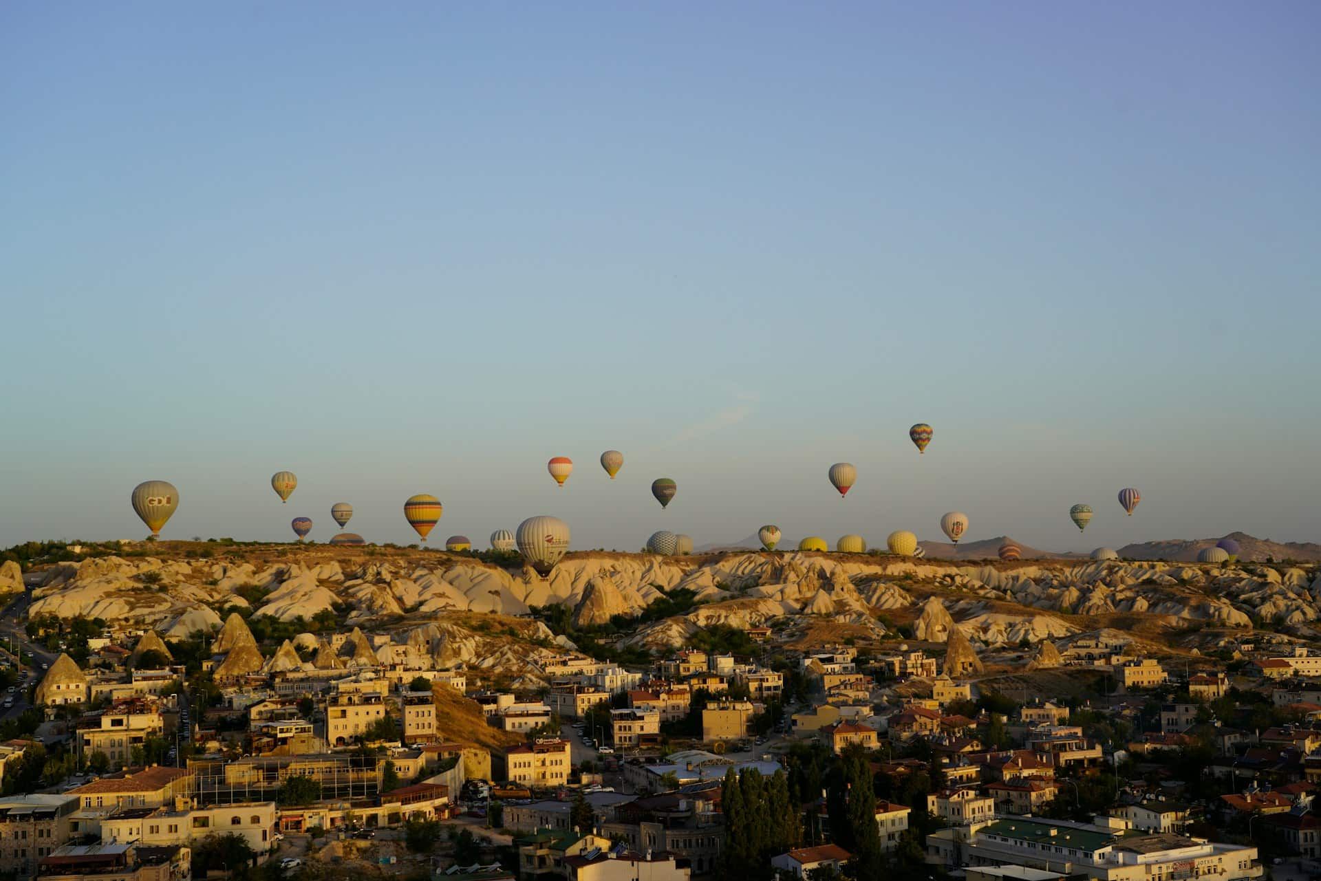Hot air balloons rising over Göreme at sunrise, Cappadocia, Turkey