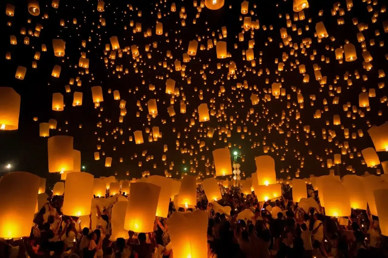 Thousands of glowing sky lanterns released into the night sky during New Year celebrations in Thailand.