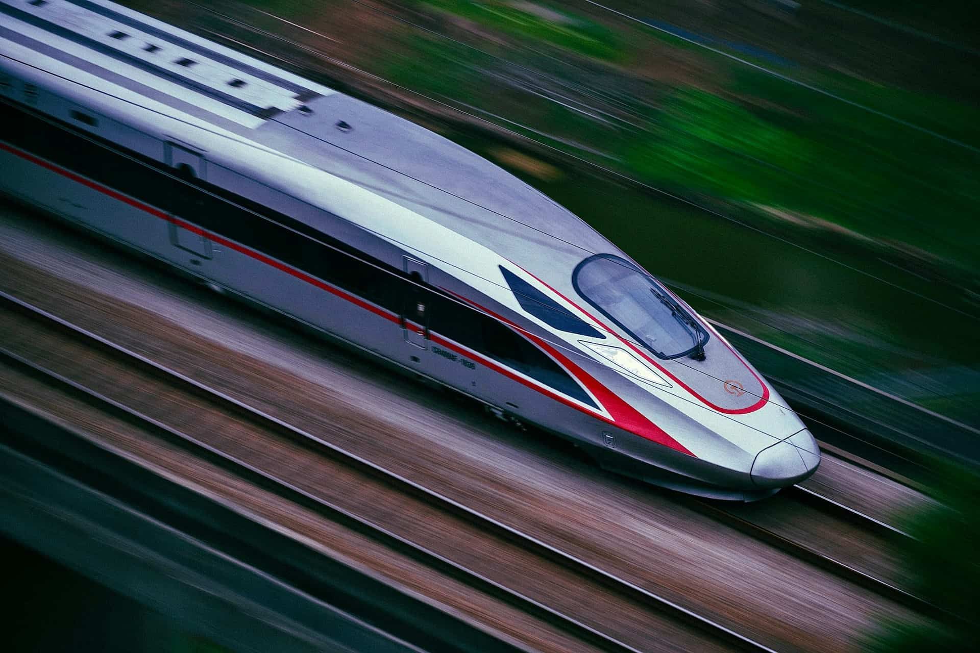 High-speed Shinkansen bullet train traveling on tracks in Japan.