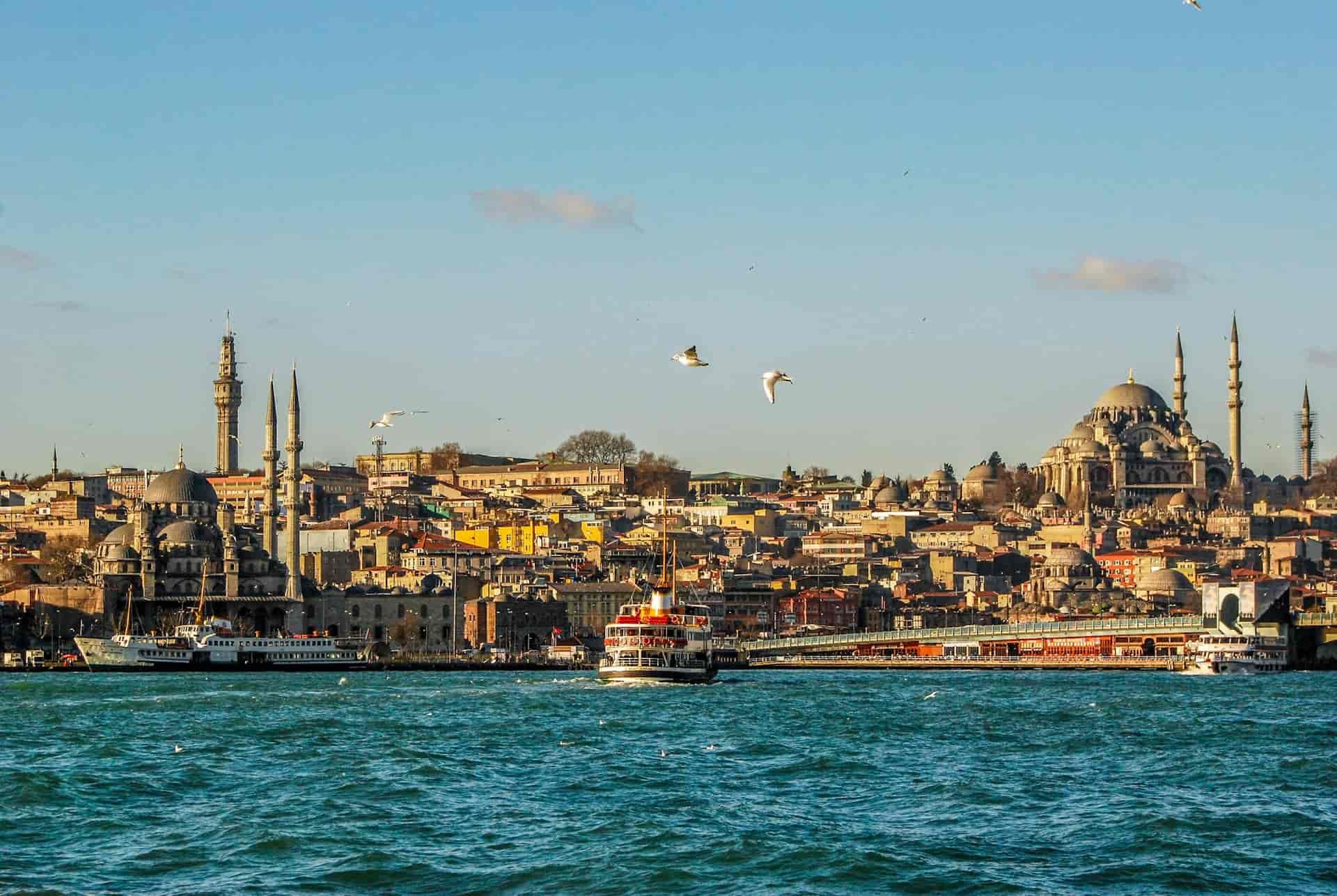 Panoramic view of Istanbul's historic skyline featuring Ottoman mosque minarets across the blue waters of the Bosphorus.