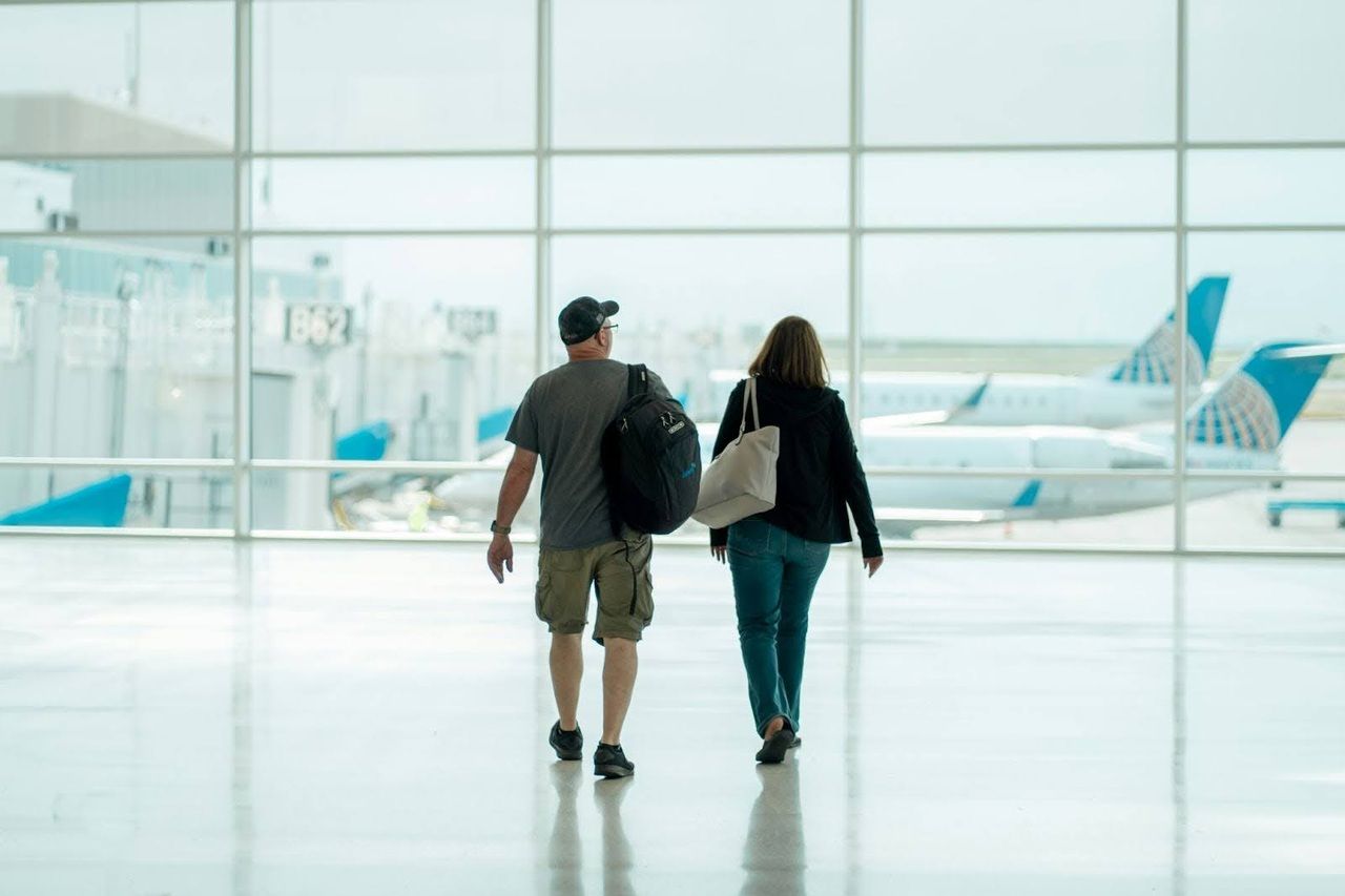 Couple walking in an airport, ready to board their flight