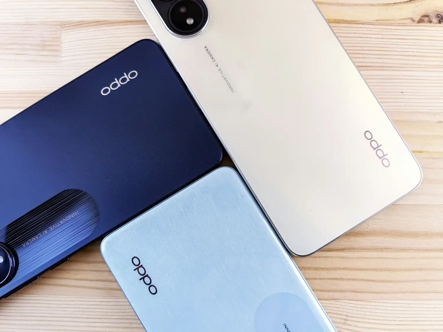 Three oppo phones sitting on top of a wooden table photo