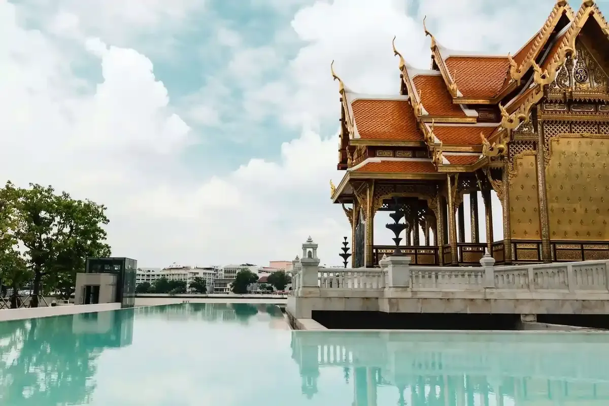 Traditional Thai architecture reflected in a serene pool, symbolizing cultural exploration and seamless mobile connectivity with travel eSIMs across Thailand, Malaysia, and Singapore.
