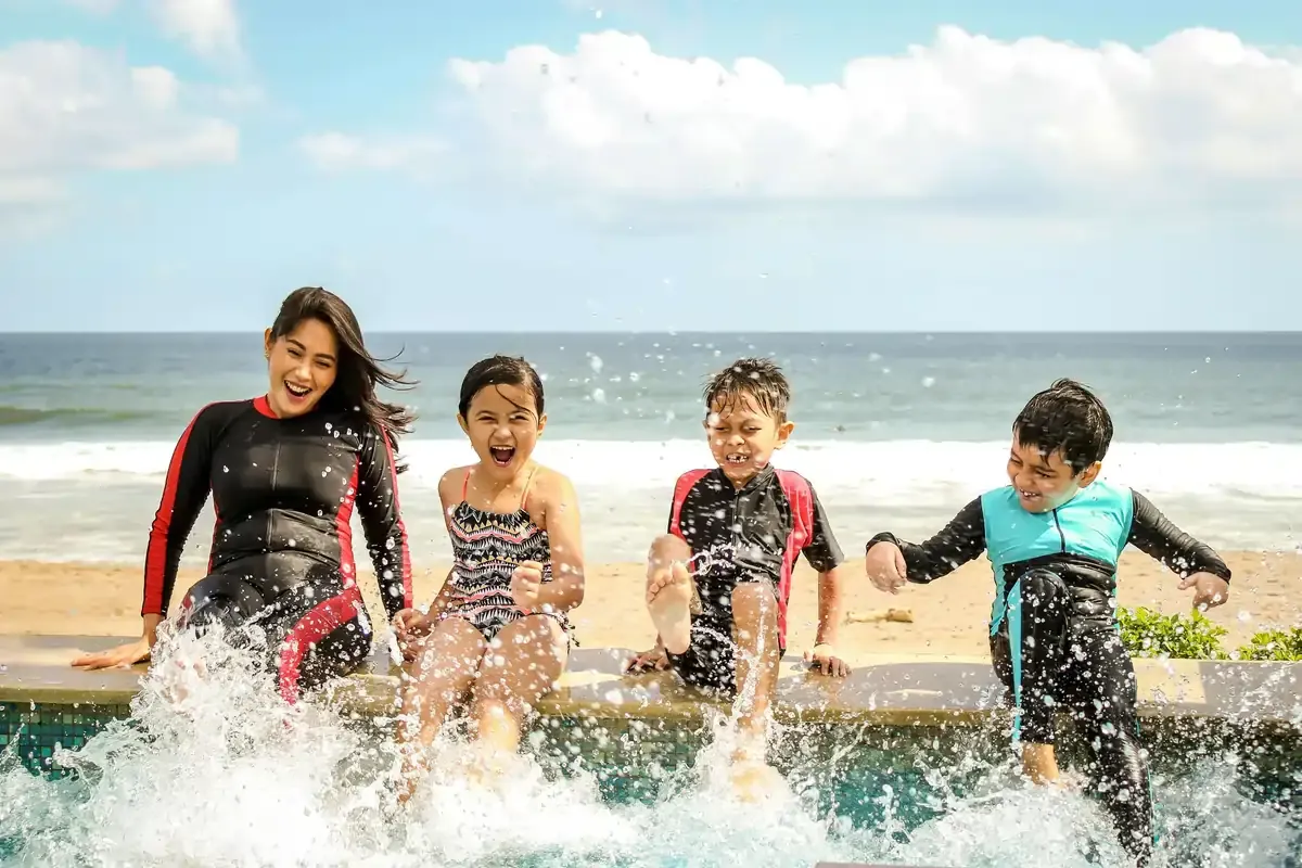 Happy family splashing water by the beach on a sunny holiday near Singapore