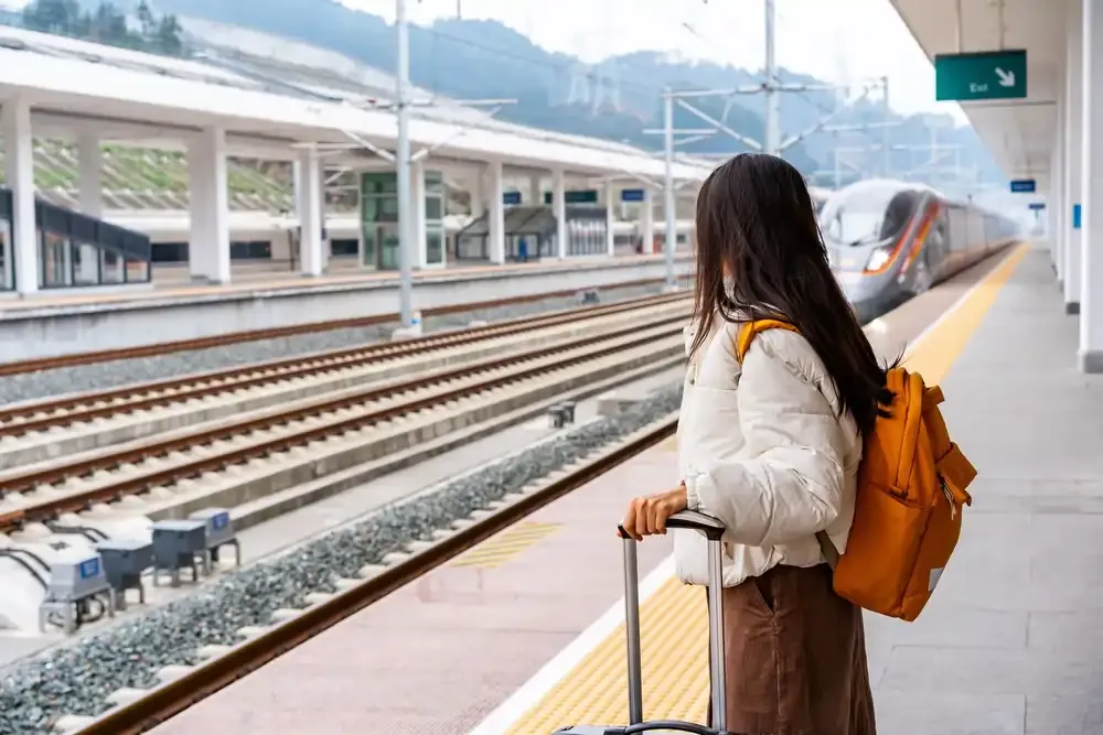 First-time traveller in Japan looking at a bullet train as it enters the station.