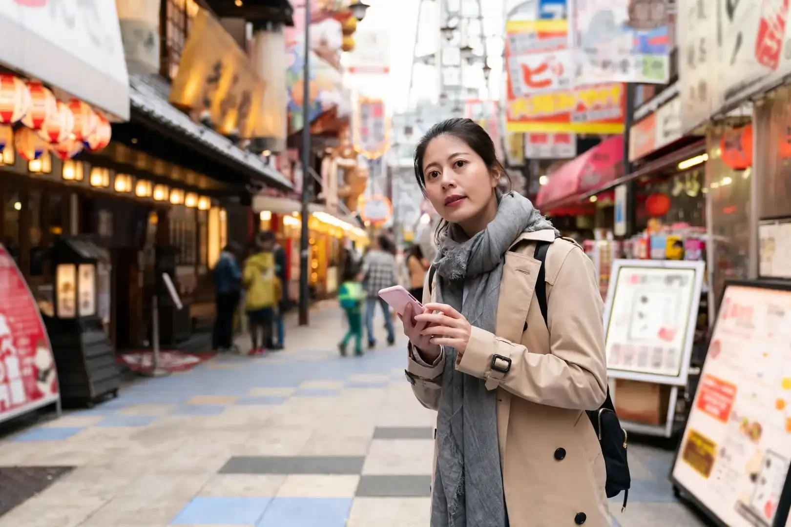 A first-time visitor to Japan looking at her phone while navigating a busy street
