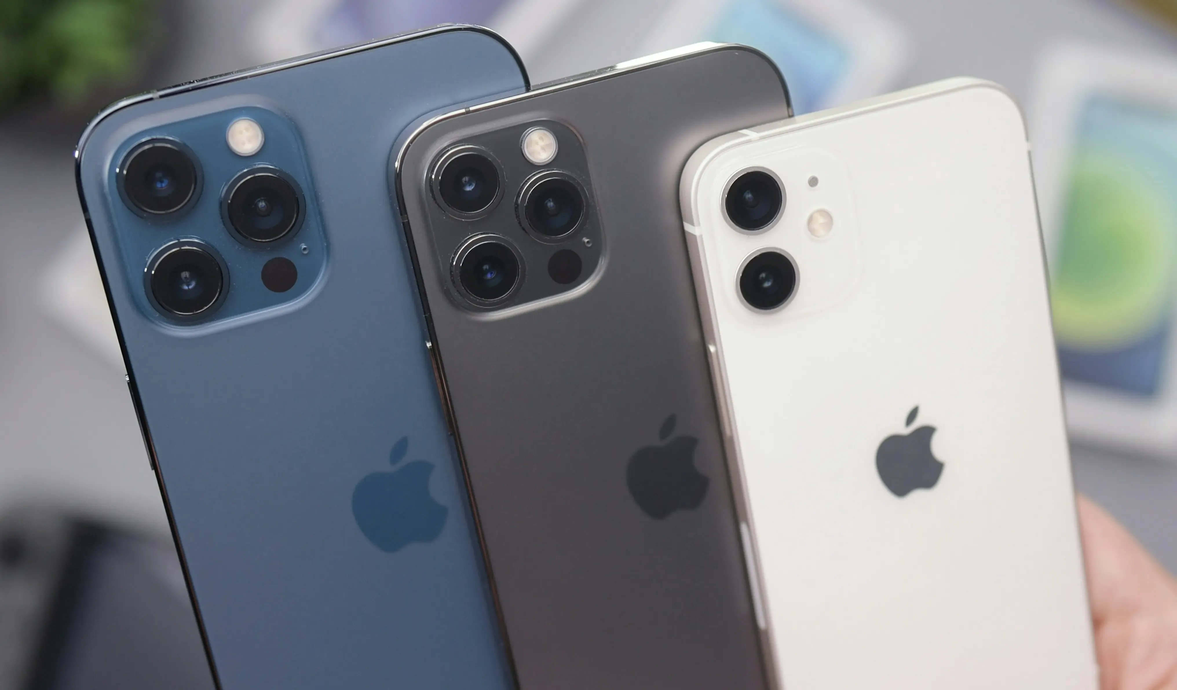Multiple Apple iPhone models displayed side by side, highlighting the rear camera layouts and color options.