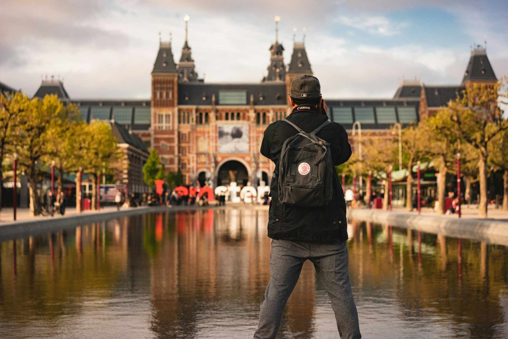 Man Photographing Building Across Water