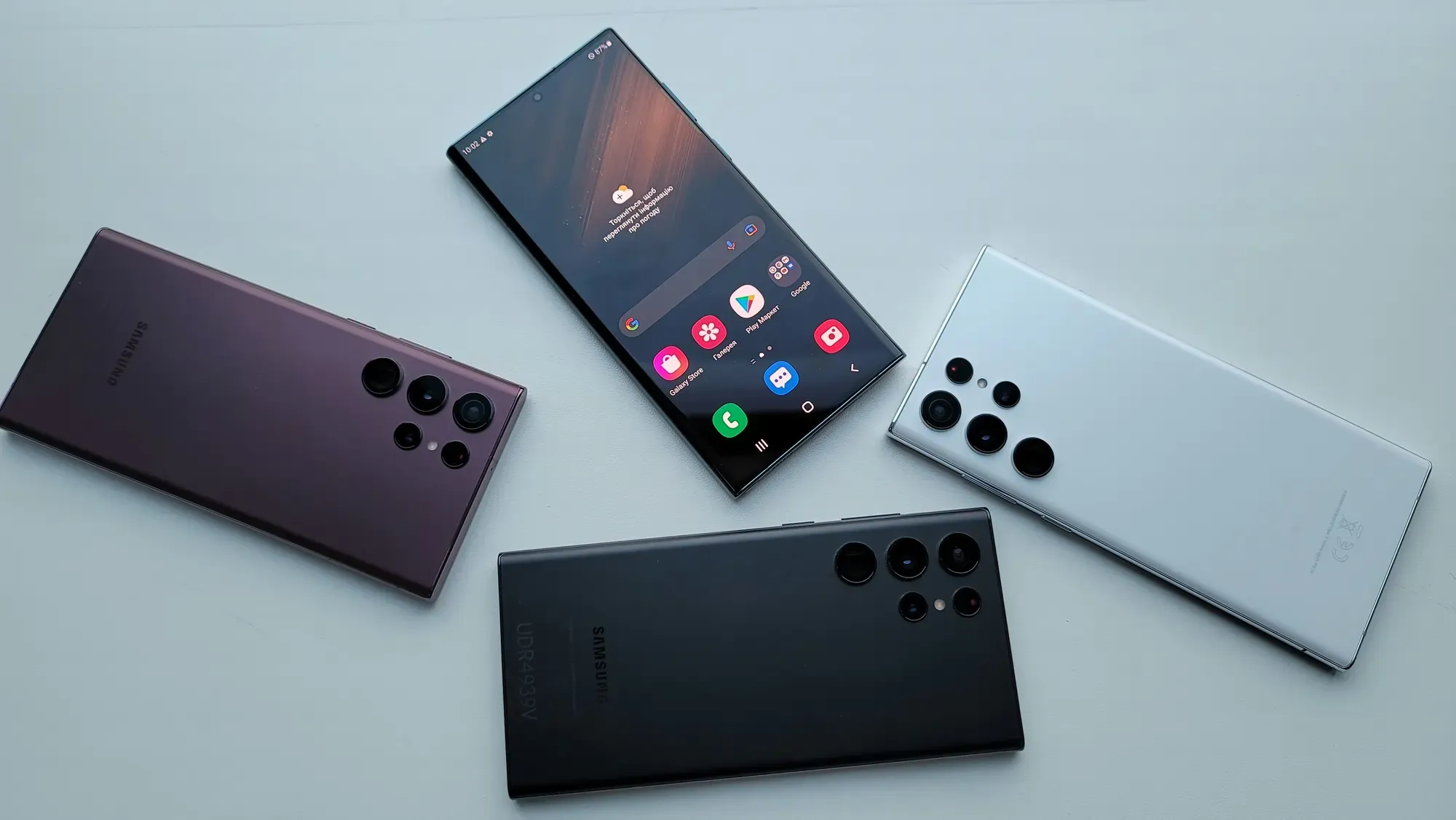 Here's alt text for this image: "Four Samsung Galaxy S24 Ultra smartphones arranged on a light blue surface