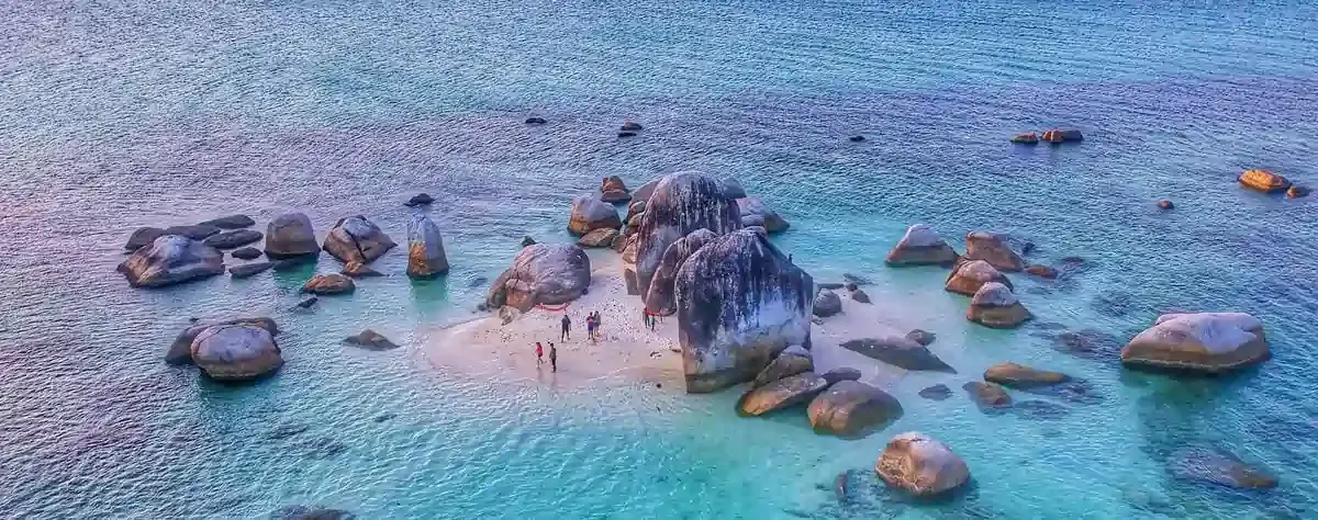 Aerial view of a small island with giant granite rocks and turquoise waters in Belitung, highlighting stunning travel destinations in Indonesia beyond Bali.