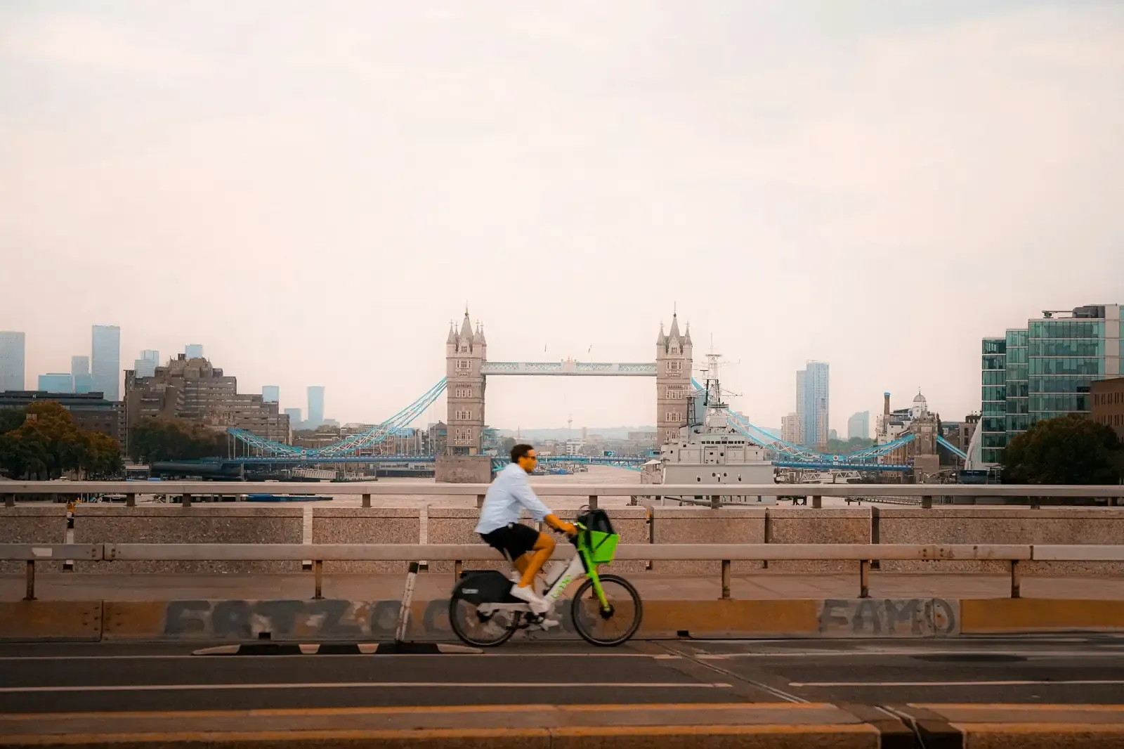 Cyclist riding past Tower Bridge and the River Thames in London