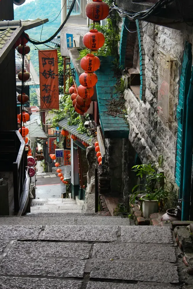 Stone staircase lined with red lanterns and traditional shops in Jiufen, Taiwan.