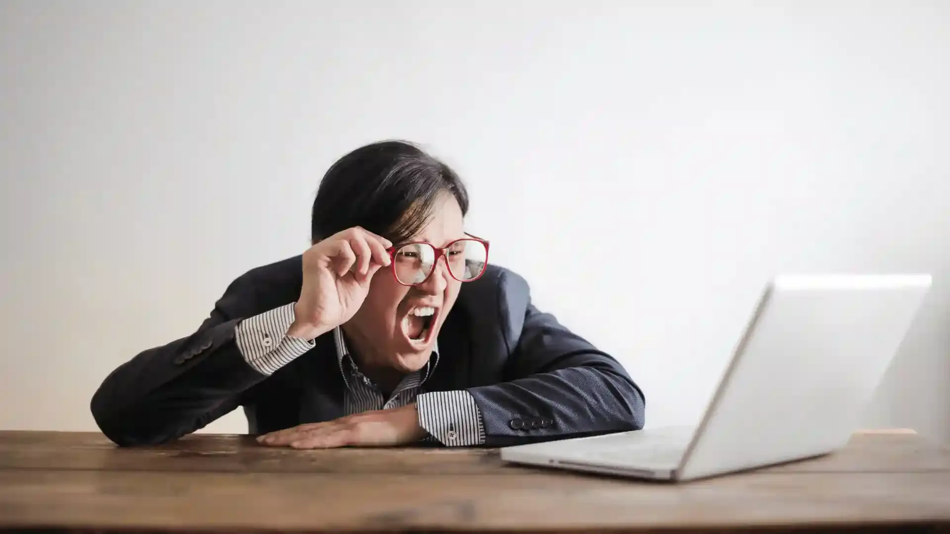 Frustrated person reacting to laptop screen, symbolizing common mistakes to avoid when buying an eSIM.