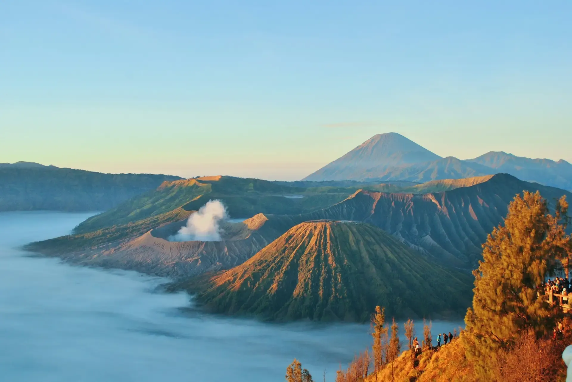Mount Bromo and Mount Semeru above the clouds at sunrise.