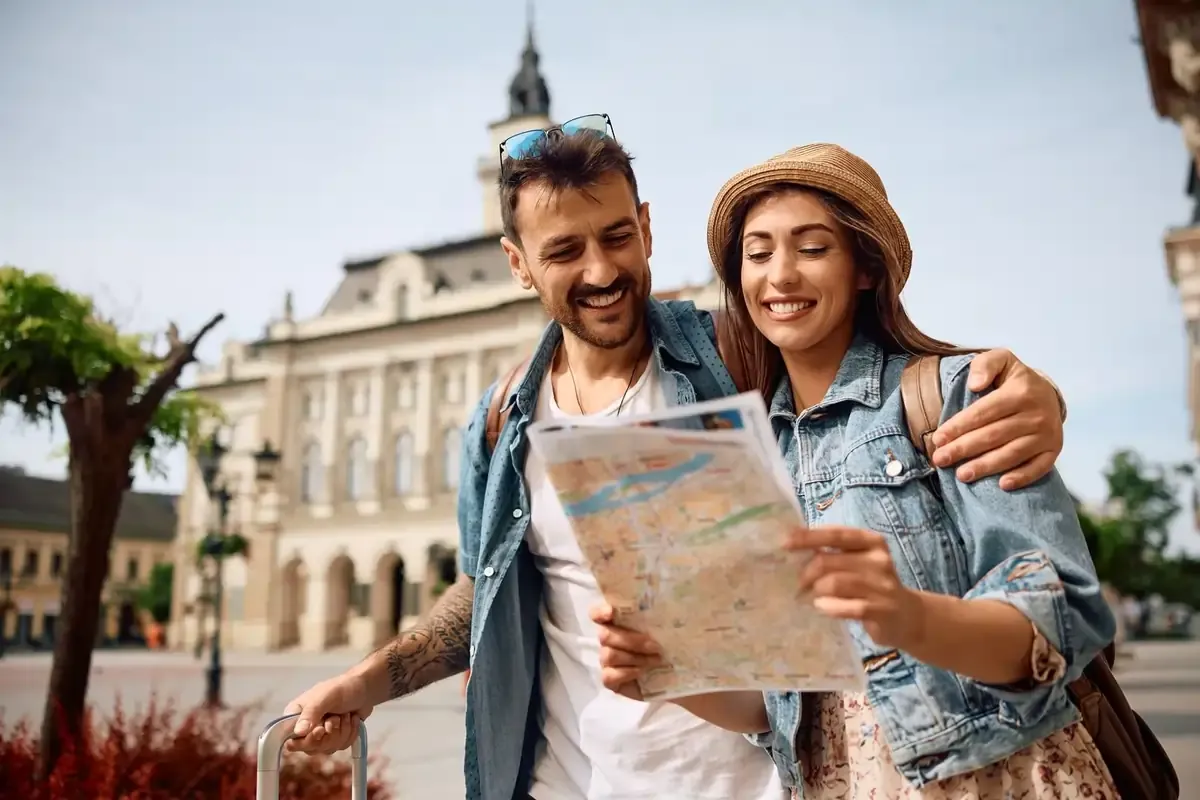 Smiling couple navigating with a city map — stay connected with an eSIM while avoiding unexpected charges during your roaming period.