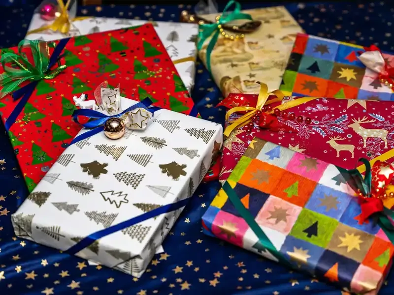 Assorted Christmas gifts wrapped in festive paper, perfect holiday presents for travelers featured in our gift guide.
