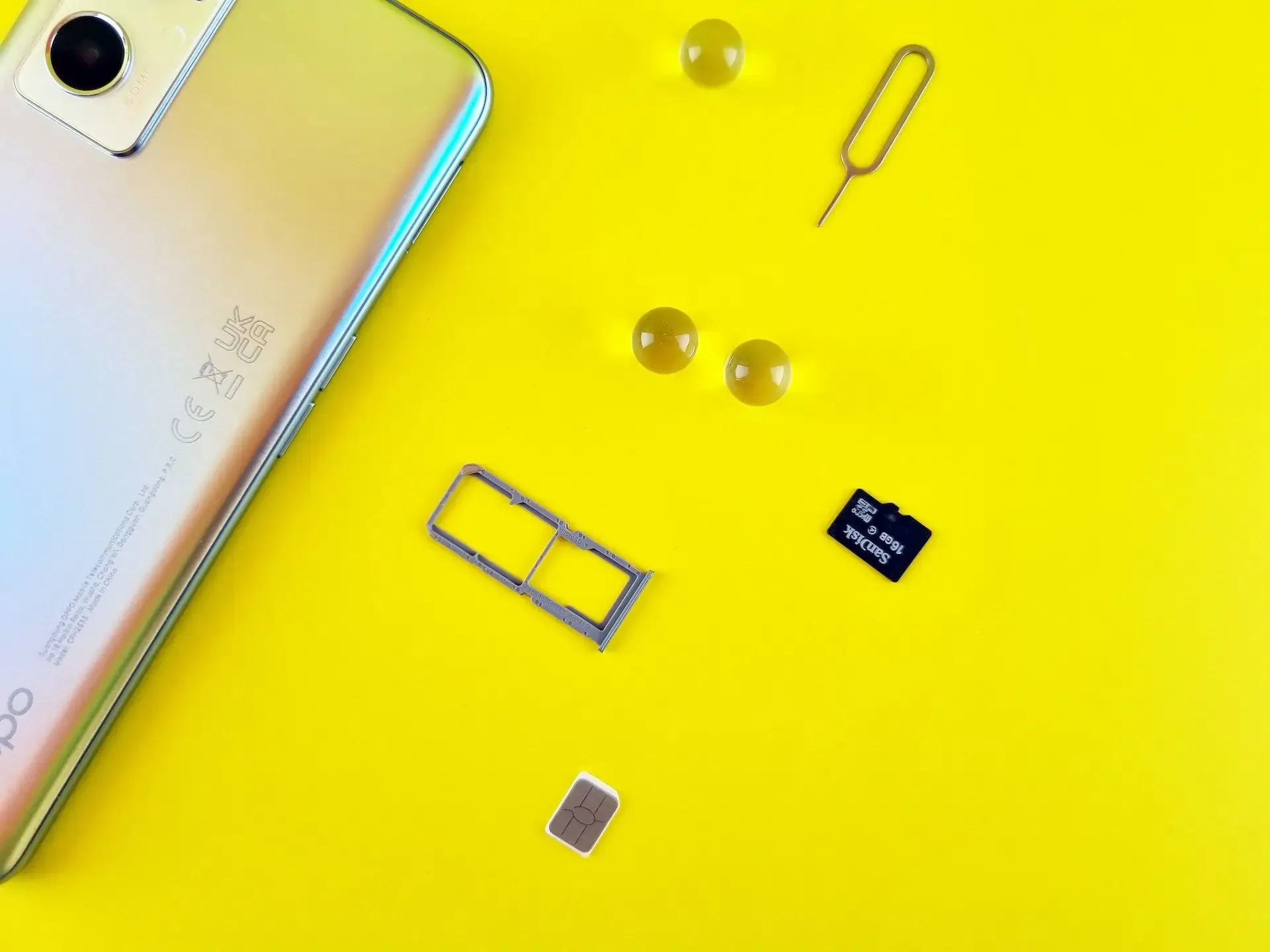 Dual SIM card setup with phone and tools on yellow background.