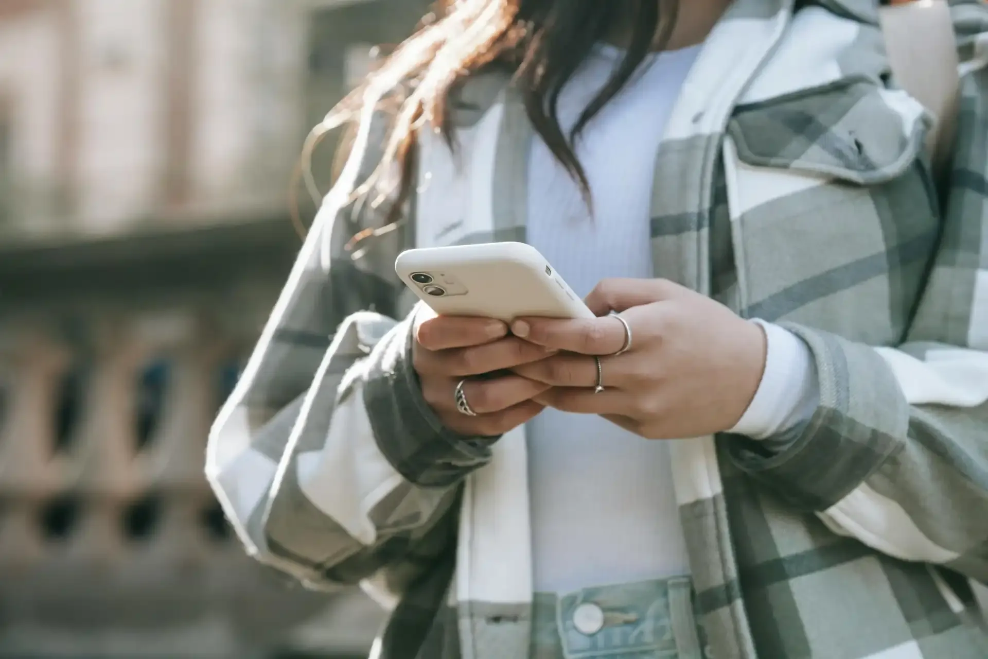 Close-up of woman using smartphone outdoors while traveling with mobile data