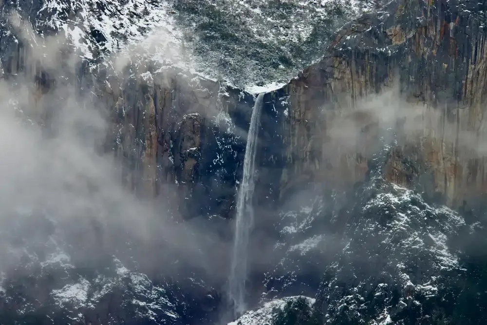 Waterfall in Yosemite National Park with mist and snow — where an eSIM helps you stay connected even in remote nature escapes.