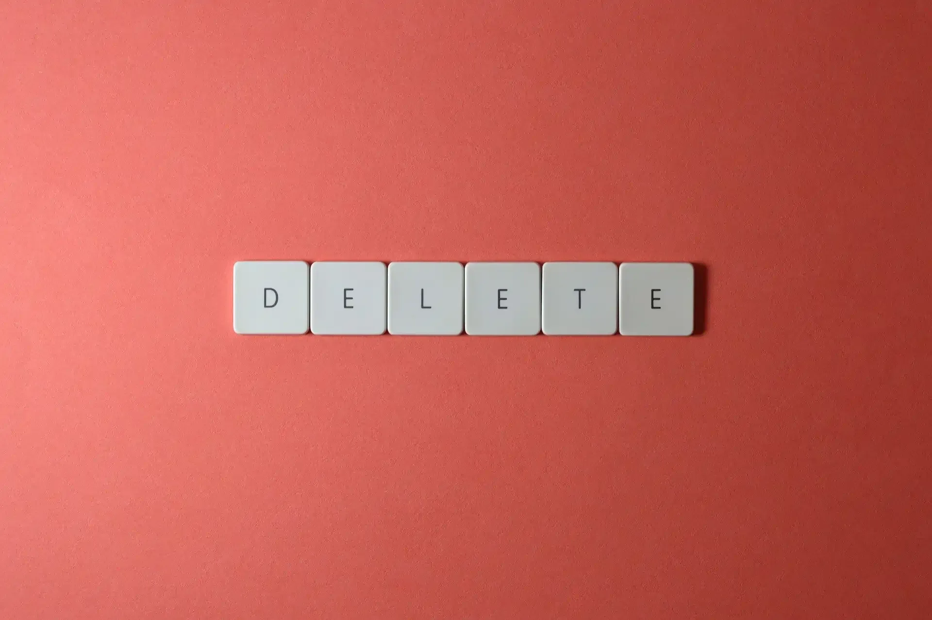 Keyboard keys spelling out DELETE on a red background, symbolising removing an eSIM