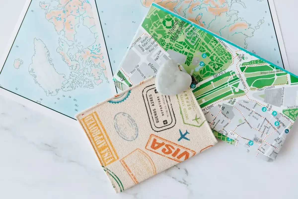 Flat lay of international travel documents and maps for multi-destination trip planning.