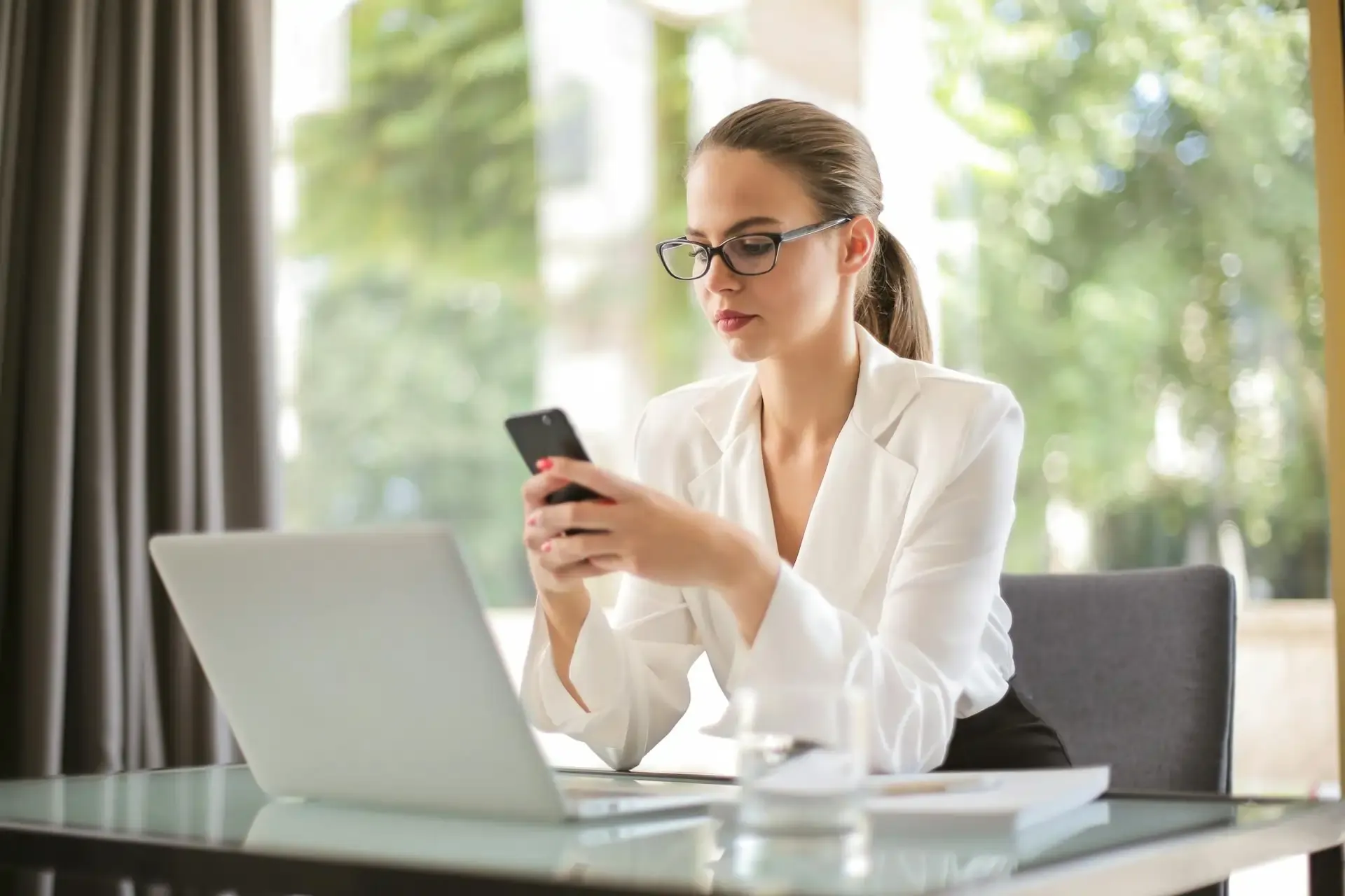 Professional woman troubleshooting her phone at a desk, navigating what to do when the eSIM doesn’t work.