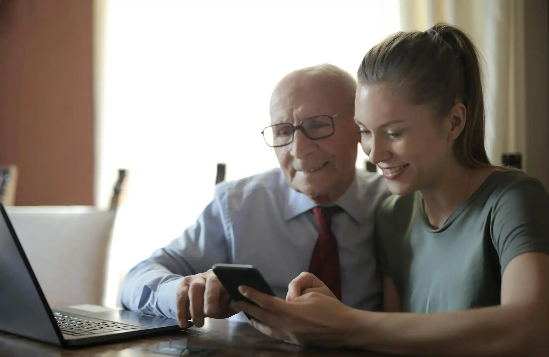 Senior man and woman reviewing phone and computer screens, highlighting troubleshooting steps for eSIM activation errors.