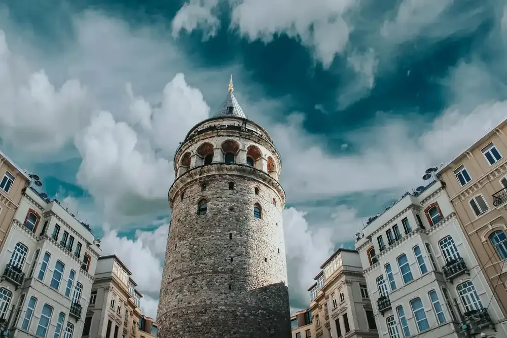 Istanbul’s Galata Tower rising above Istanbul rooftops under a dramatic sky, highlighting the city’s connectivity and free airport Wi-Fi for tourists.