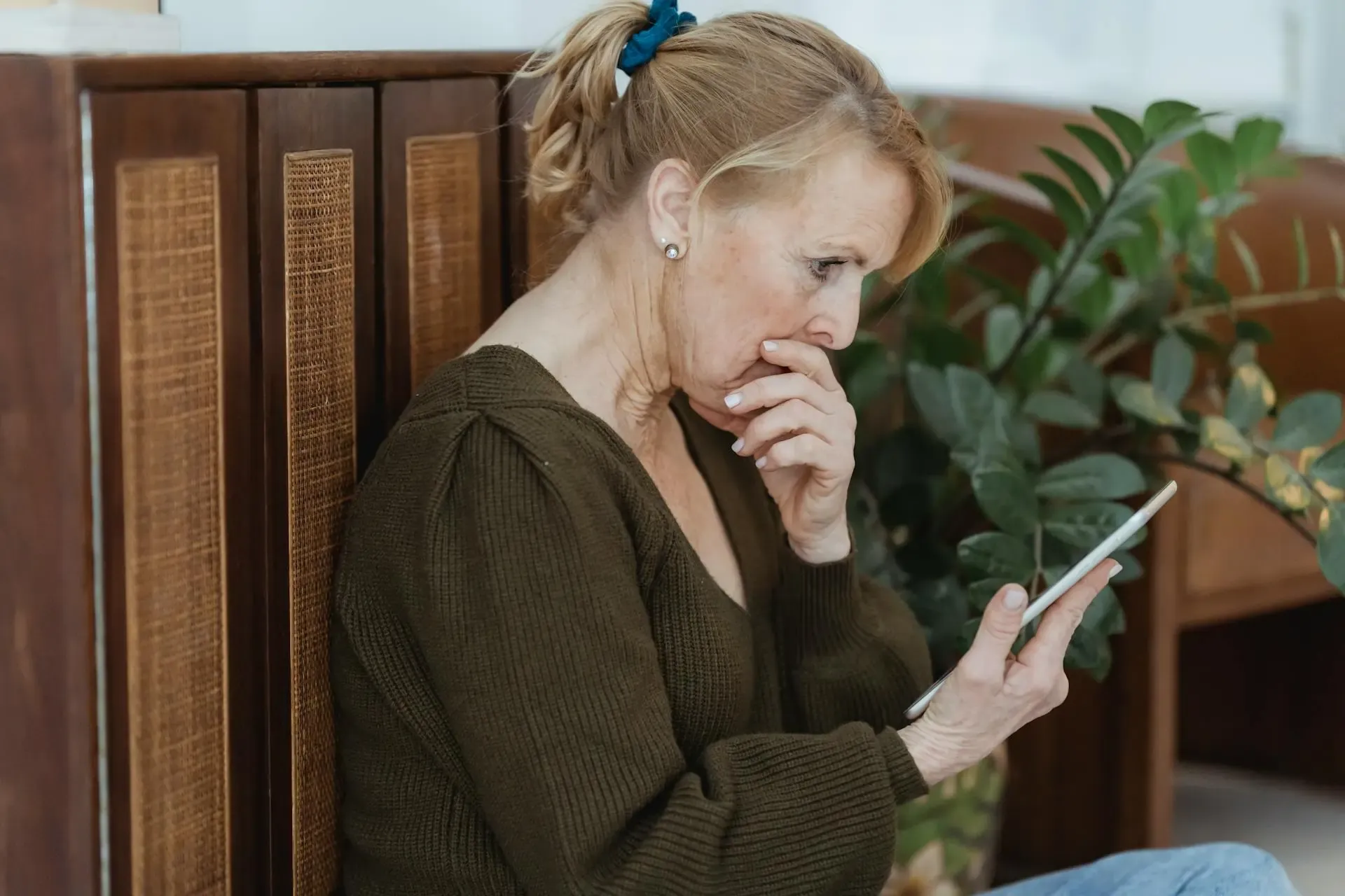 Concerned woman looking at her smartphone, illustrating the frustration of unexpectedly high mobile data usage.