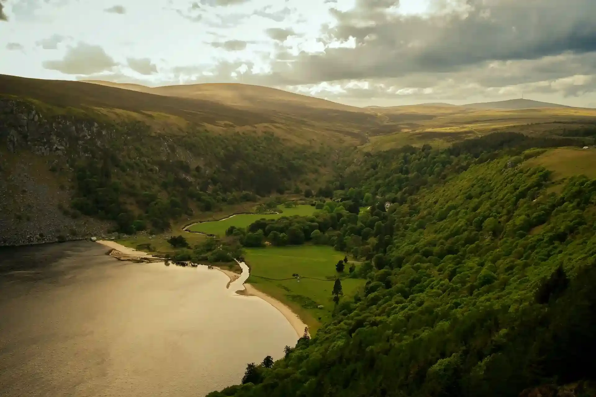 Scenic view of lush green hills and a lake in Ireland, symbolizing uninterrupted connectivity with eSIMs while exploring the UK and Ireland.