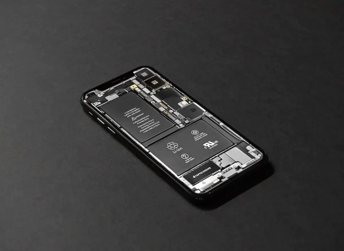 Smartphone with its internal hardware exposed, illustrating components like battery and circuit boards.