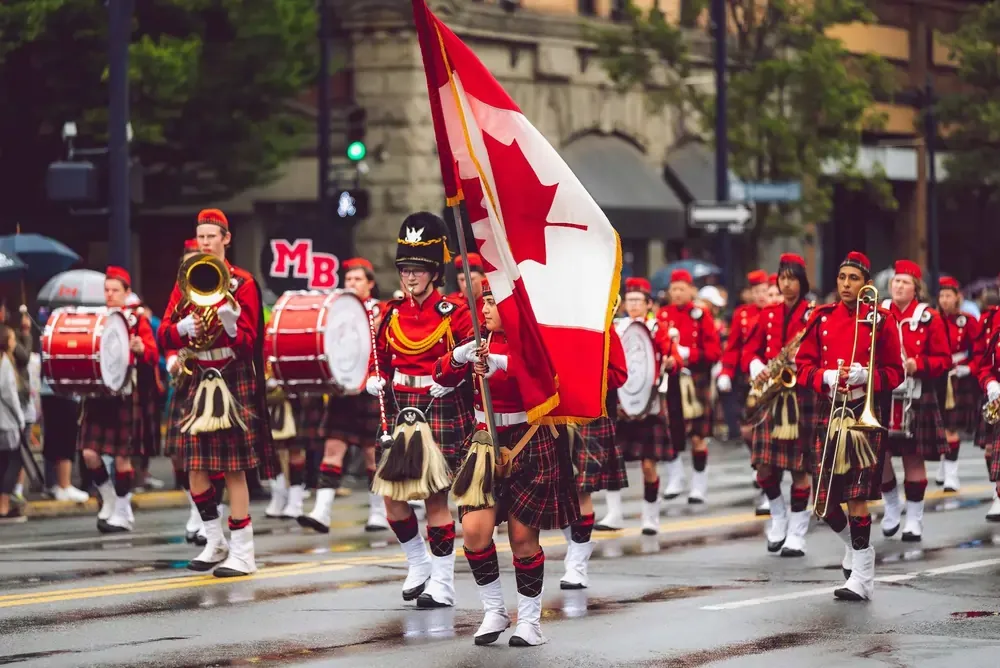 Canada Day parade with marching band in traditional Scottish attire, showcasing Canadian pride