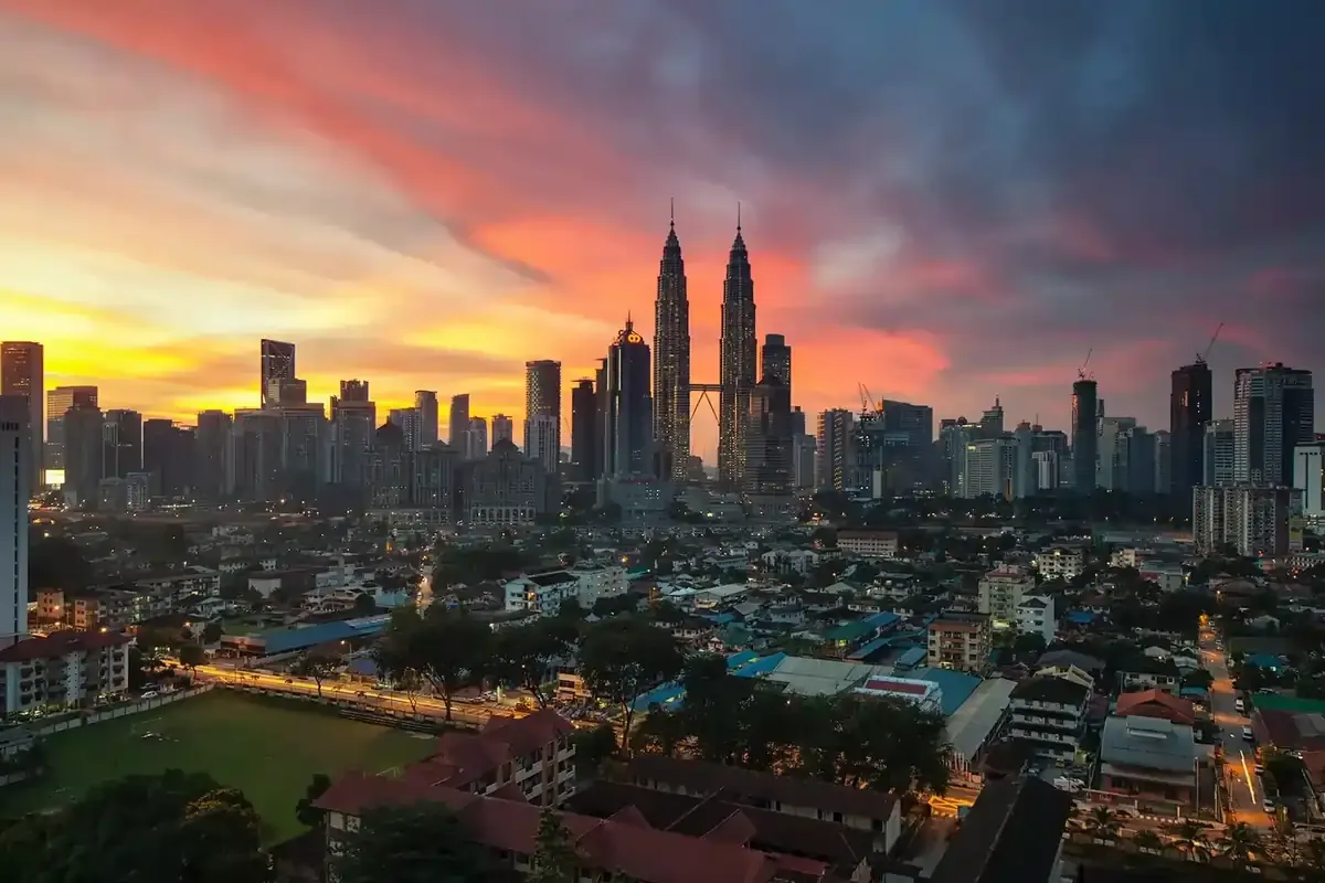 Kuala Lumpur city skyline at sunset featuring the Petronas Twin Towers