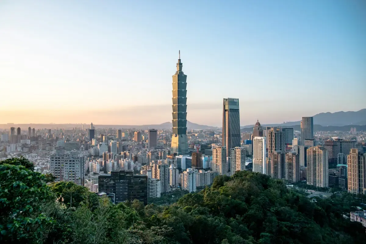 Taipei skyline with Taipei 101 rising above the city at sunset.