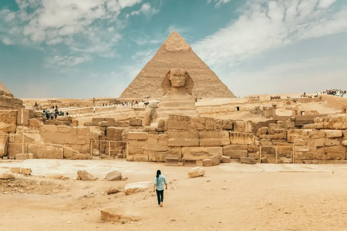 Traveller approaching the Great Sphinx with the Pyramid of Khafre behind it.