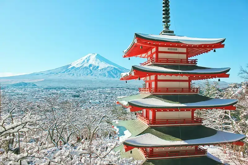 Snow-covered Chureito Pagoda with Mount Fuji in the background on a clear day in Japan